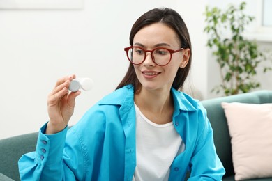 Photo of Woman in glasses with contact lenses on sofa indoors