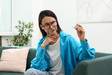 Photo of Woman in glasses with contact lenses on sofa indoors
