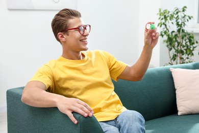 Photo of Man in glasses with contact lenses on sofa indoors