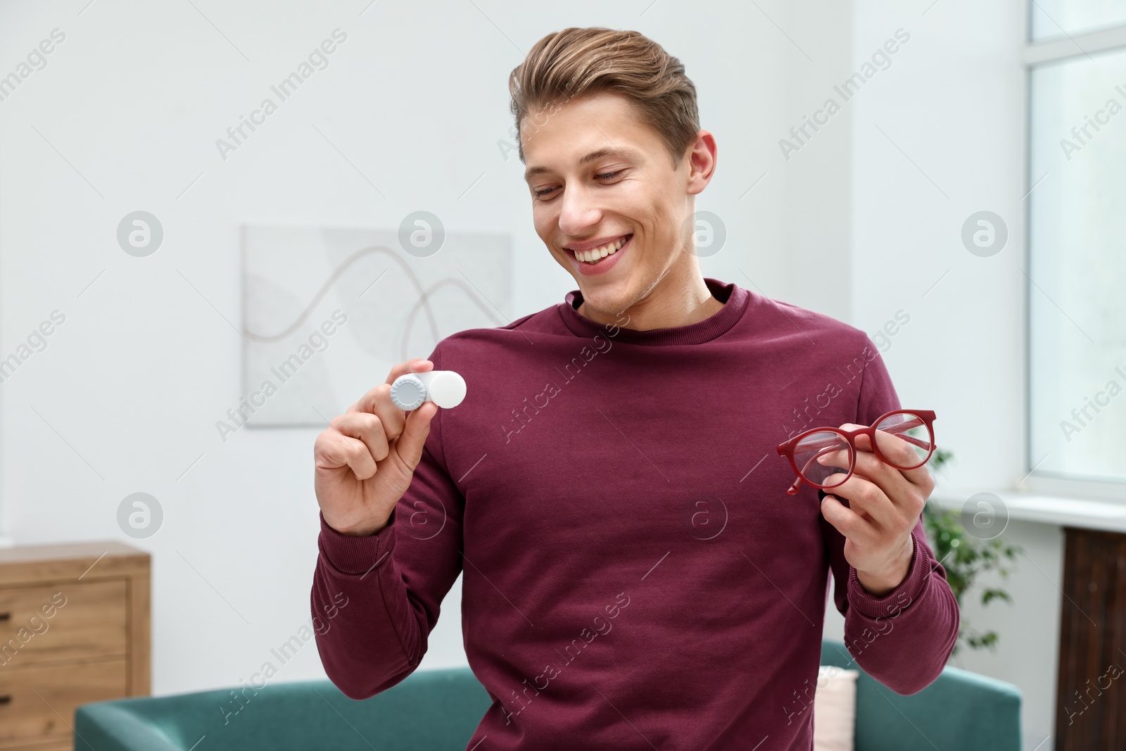 Photo of Man choosing between glasses and contact lenses indoors