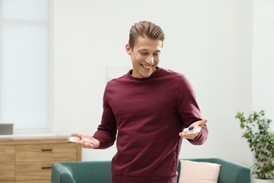 Photo of Man choosing between glasses and contact lenses indoors