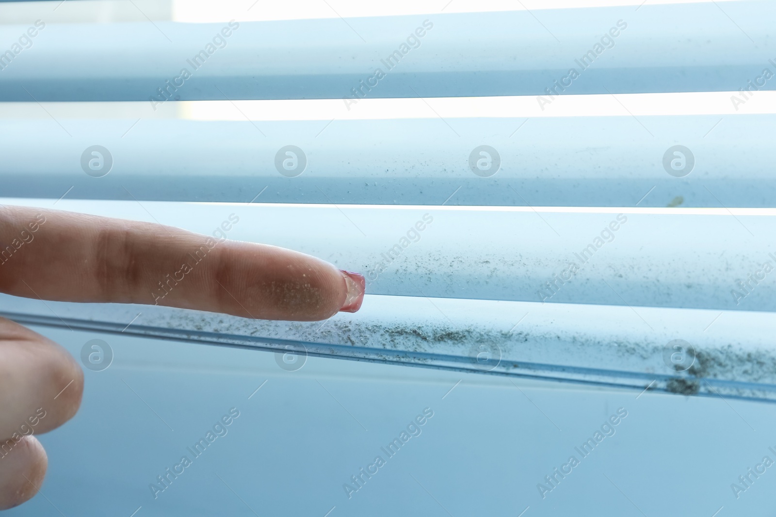 Woman showing dust from window blinds indoors, closeup Photo of Woman showing dust from window blinds indoors, closeup