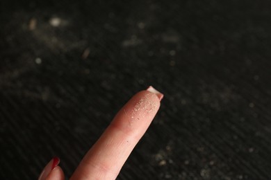 Photo of Woman swiping dust from black wooden table, closeup