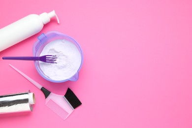 Photo of Care cosmetic product for blonde hair in bowl and hairdresser's tools on pink background, flat lay. Space for text