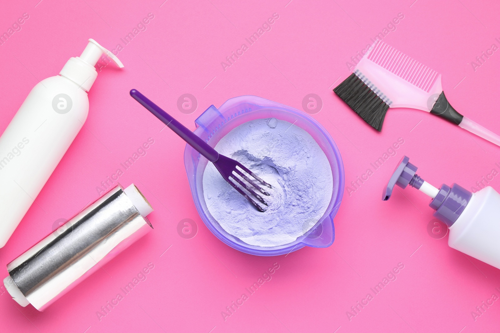 Photo of Care cosmetic product for blonde hair in bowl and hairdresser's tools on pink background, flat lay
