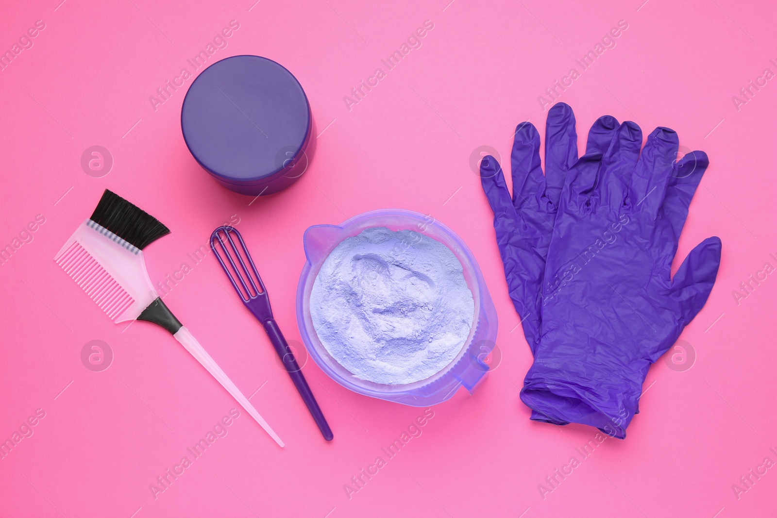 Photo of Care cosmetic product for blonde hair in bowl and hairdresser's tools on pink background, flat lay