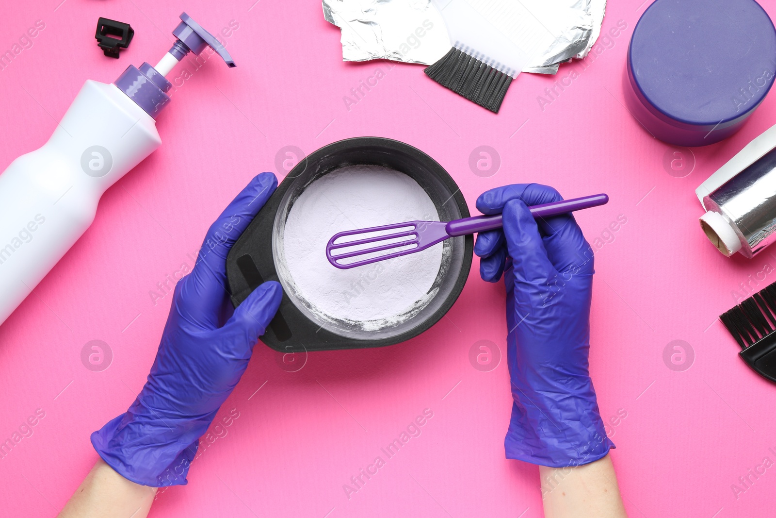 Photo of Woman making hair care product for blonde hair on pink background, top view