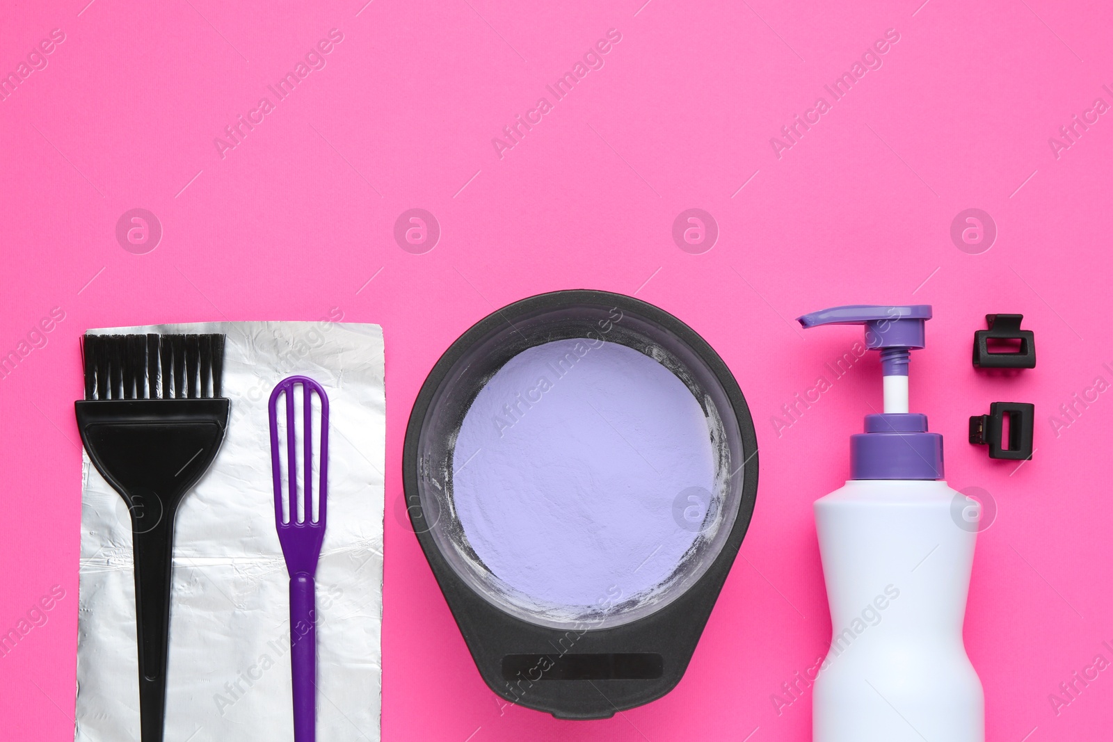 Photo of Care cosmetic product for blonde hair in bowl and hairdresser's tools on pink background, flat lay. Space for text