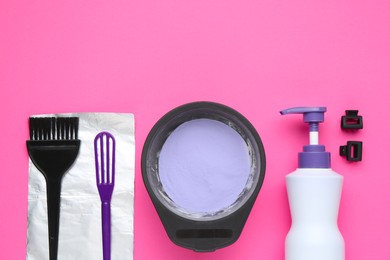Photo of Care cosmetic product for blonde hair in bowl and hairdresser's tools on pink background, flat lay. Space for text