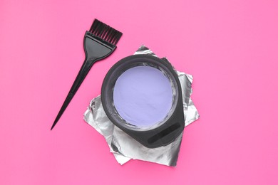 Photo of Care cosmetic product for blonde hair in bowl, foil and brush on pink background, flat lay