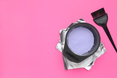 Photo of Care cosmetic product for blonde hair in bowl, foil and brush on pink background, flat lay. Space for text