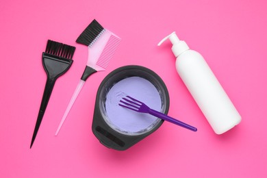 Photo of Care cosmetic product for blonde hair in bowl and hairdresser's tools on pink background, flat lay
