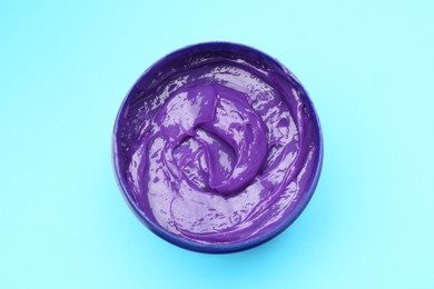 Photo of Care cosmetic product for blonde hair in jar on light blue background, top view