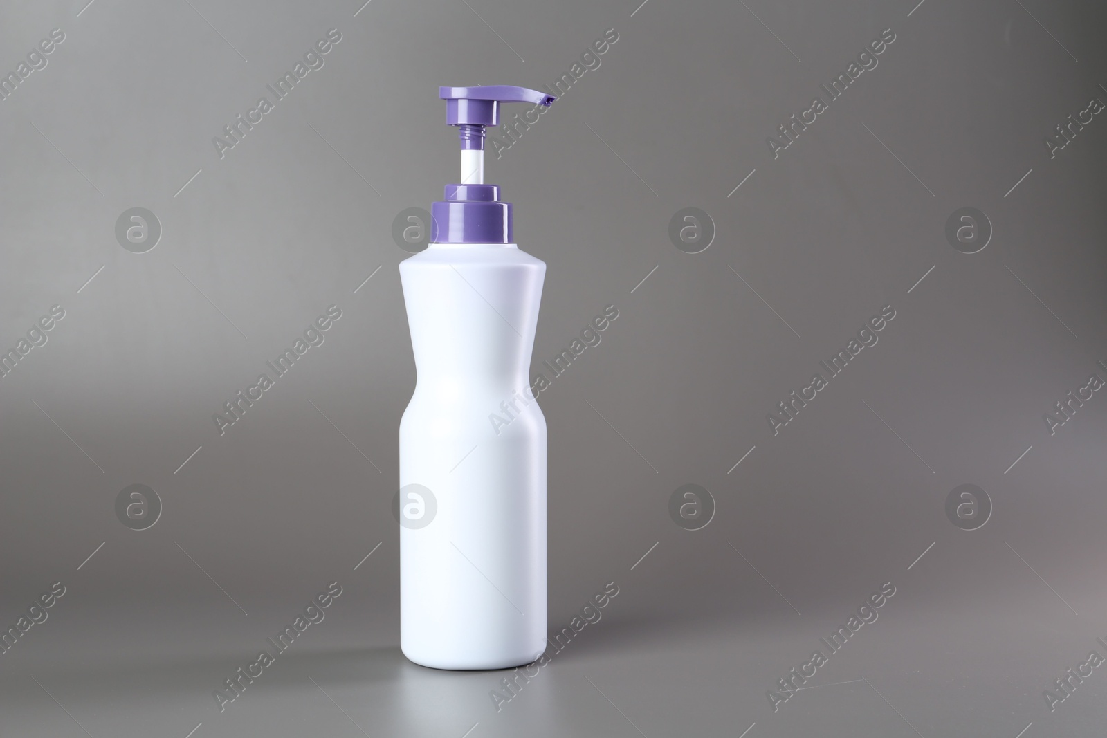 Photo of Hair care product for blonde hair in bottle on grey background, space for text
