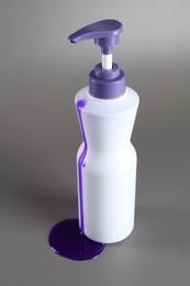 Photo of Hair care product for blonde hair in bottle on grey background, closeup