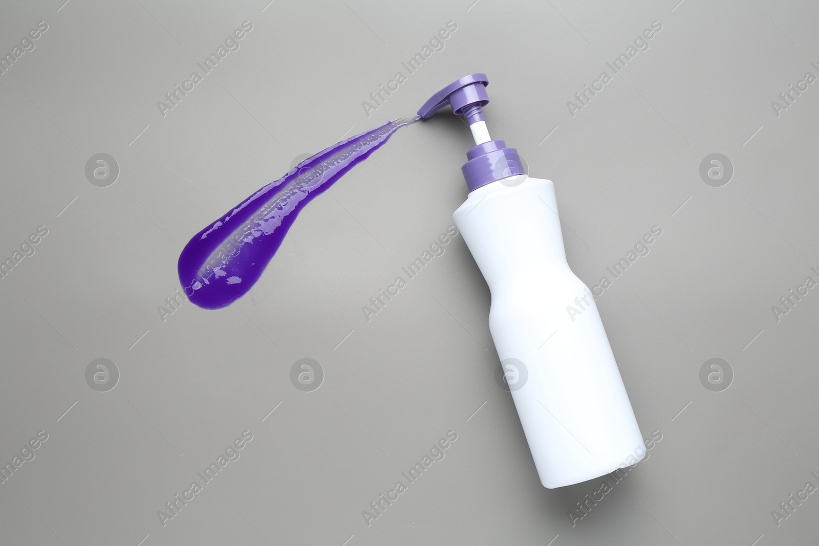 Photo of Hair care product for blonde hair in bottle and sample on grey background, top view