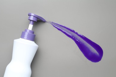 Photo of Hair care product for blonde hair in bottle and sample on grey background, top view