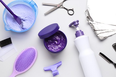 Photo of Hair care product for blonde hair and hairdresser's tools on white background, flat lay