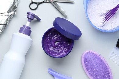 Photo of Hair care product for blonde hair and hairdresser's tools on white background, flat lay