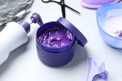 Photo of Hair care product for blonde hair and hairdresser's tools on white background, closeup