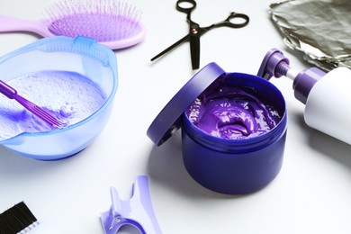 Photo of Hair care product for blonde hair and hairdresser's tools on white background, closeup