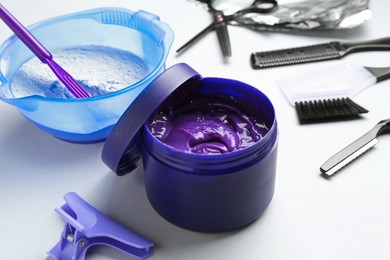 Photo of Hair care product for blonde hair and hairdresser's tools on white background, closeup