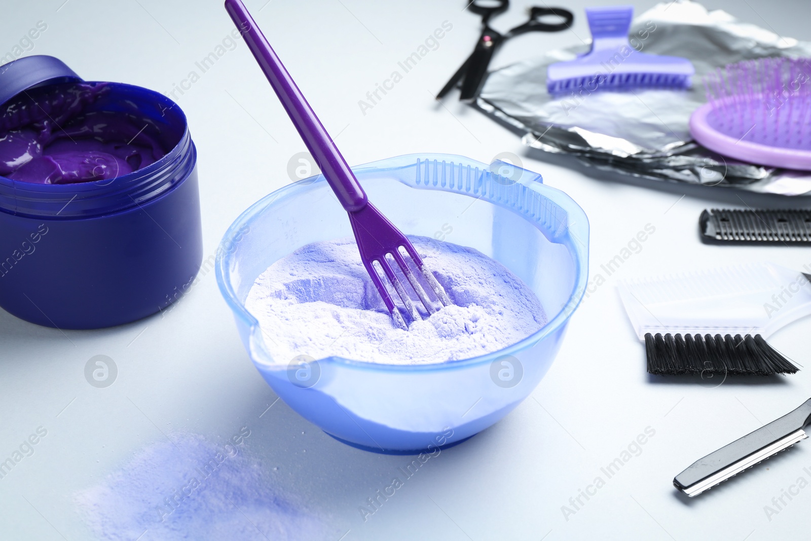 Photo of Hair care product for blonde hair and hairdresser's tools on white background, closeup