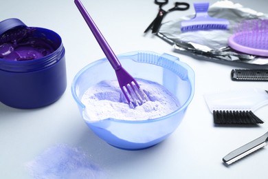 Photo of Hair care product for blonde hair and hairdresser's tools on white background, closeup