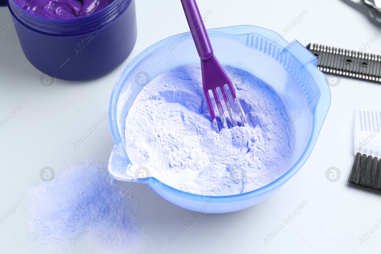 Photo of Hair care product for blonde hair and hairdresser's tools on white background, closeup