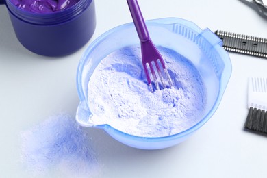 Photo of Hair care product for blonde hair and hairdresser's tools on white background, closeup
