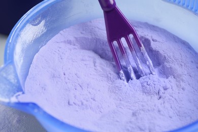 Photo of Hair care product for blonde hair and spatula in bowl, closeup