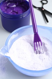Photo of Hair care product for blonde hair and hairdresser's tools on white background, closeup
