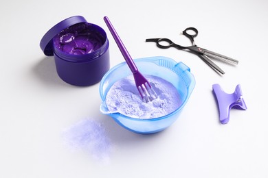 Photo of Hair care product for blonde hair and hairdresser's tools on white background
