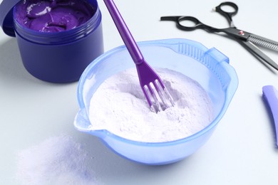 Photo of Hair care product for blonde hair and hairdresser's tools on white background, closeup