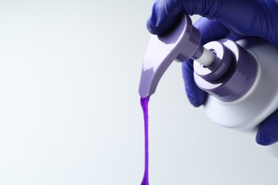 Photo of Woman pouring hair care product for blonde hair from bottle on white background, closeup. Space for text