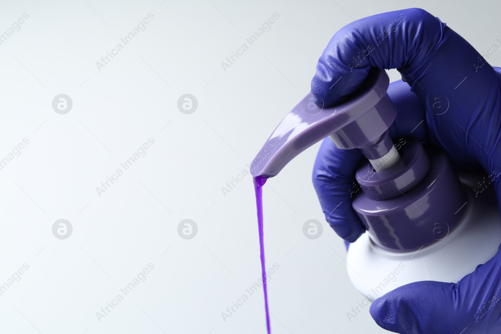Photo of Woman pouring hair care product for blonde hair from bottle on white background, closeup. Space for text