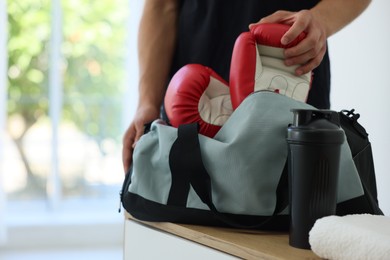 Photo of Man packing his sports bag indoors, closeup. Space for text