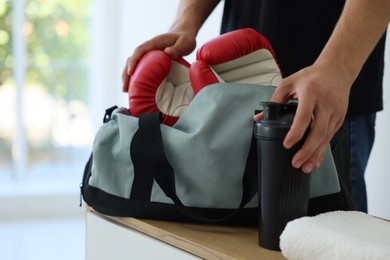 Photo of Man packing his sports bag indoors, closeup