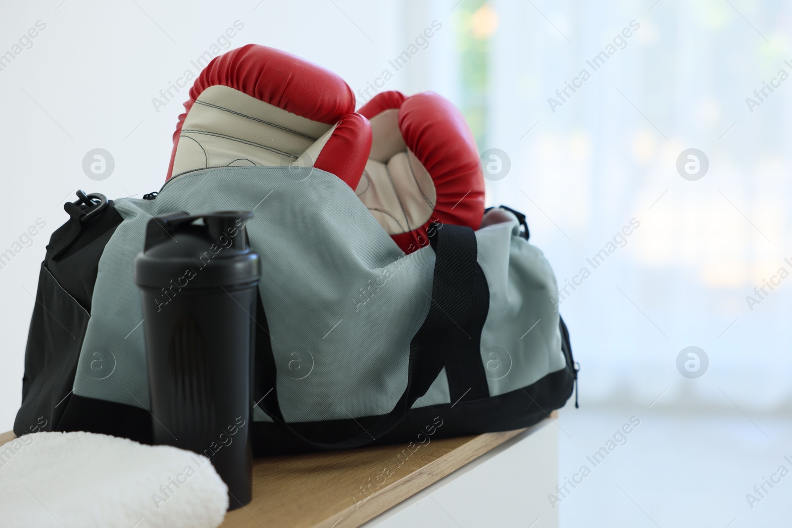 Photo of Stylish bag with sports equipment on wooden table at home
