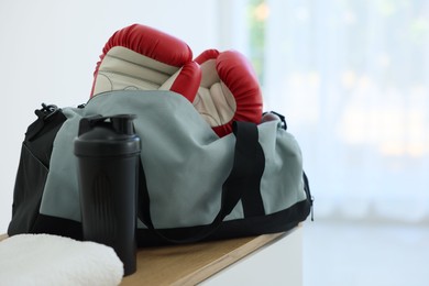 Photo of Stylish bag with sports equipment on wooden table at home