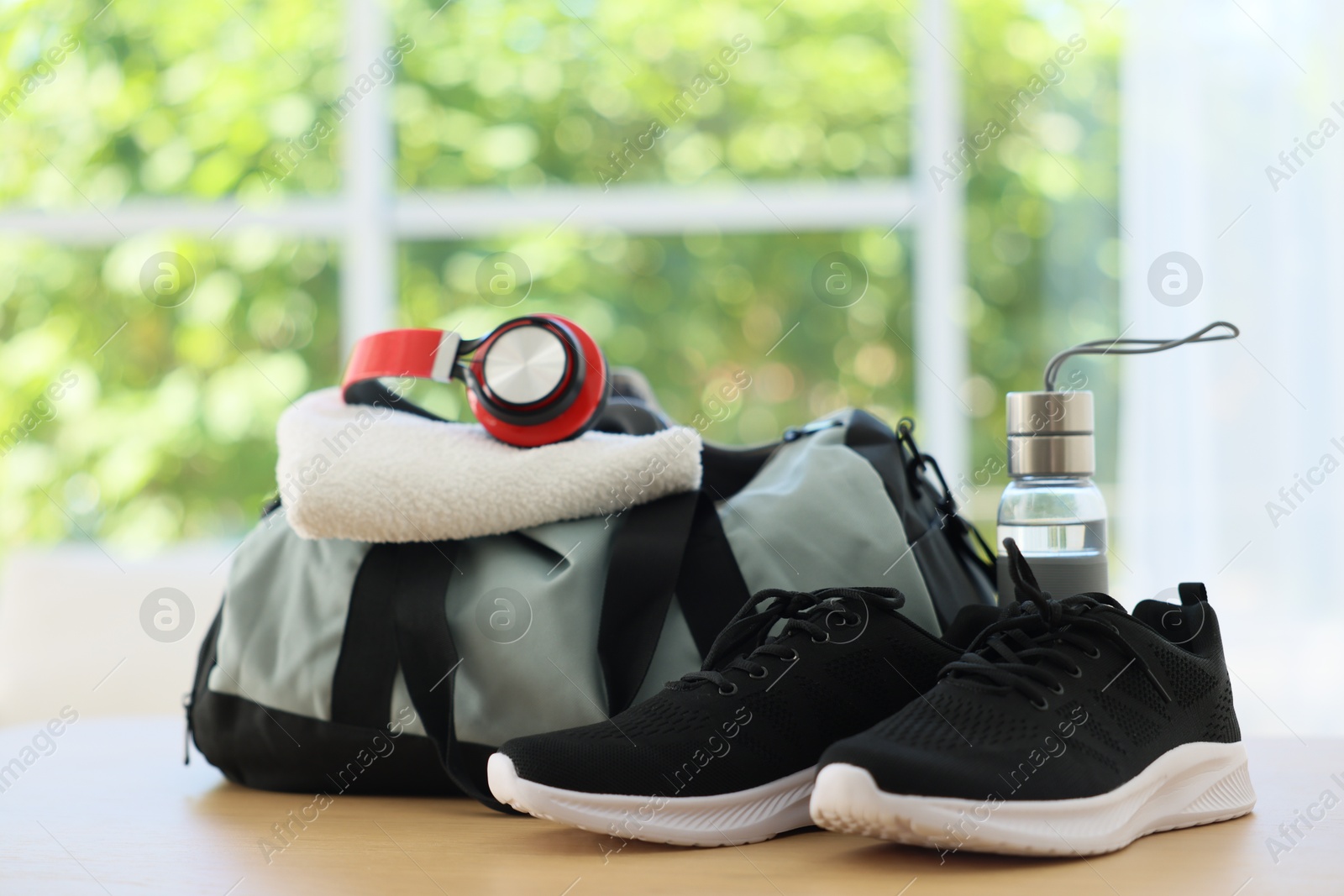 Photo of Stylish bag with sports equipment on wooden table at home