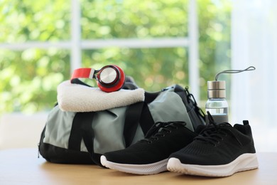Photo of Stylish bag with sports equipment on wooden table at home