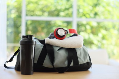Photo of Stylish bag with sports equipment on wooden table at home