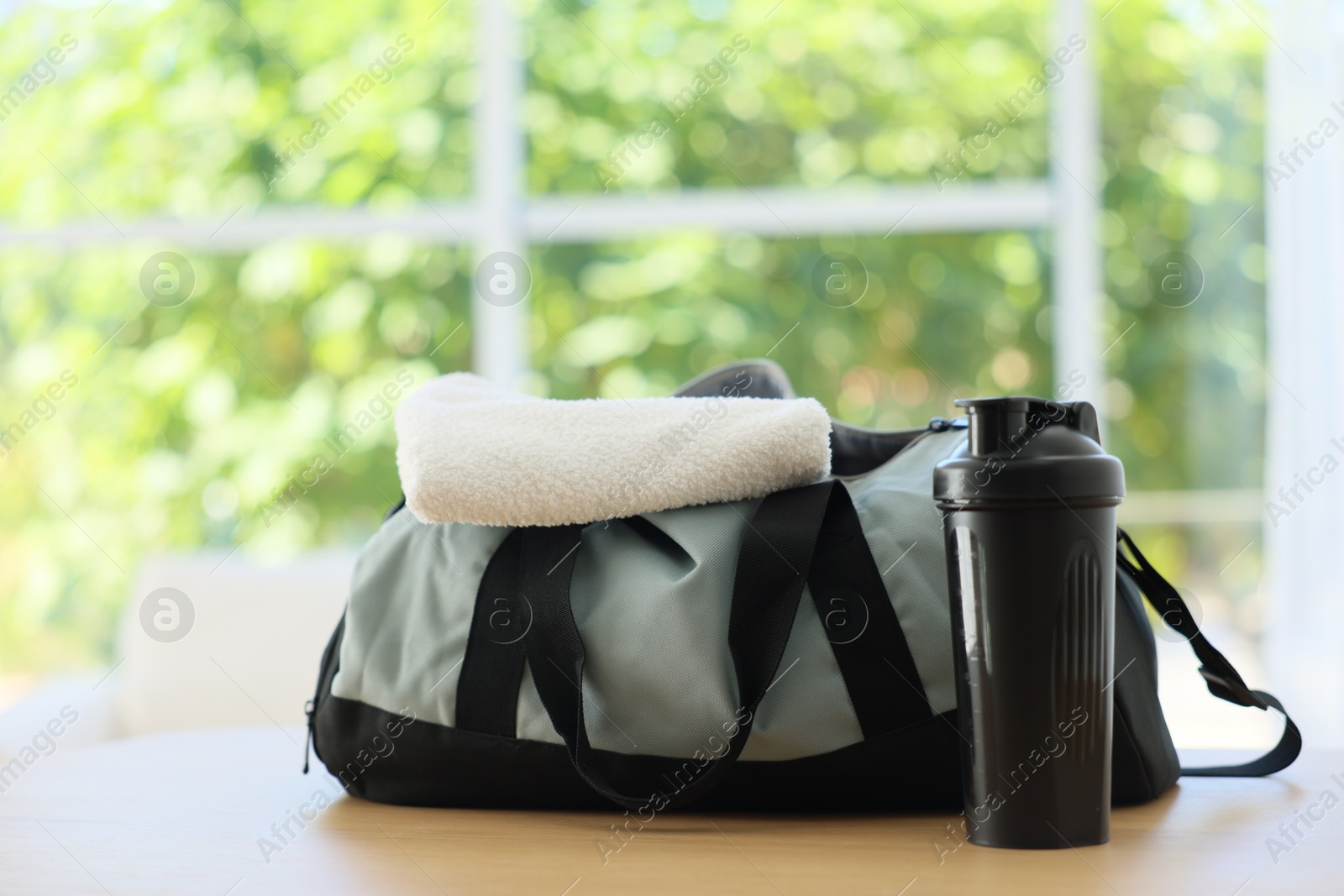 Photo of Stylish bag with sports equipment on wooden table at home