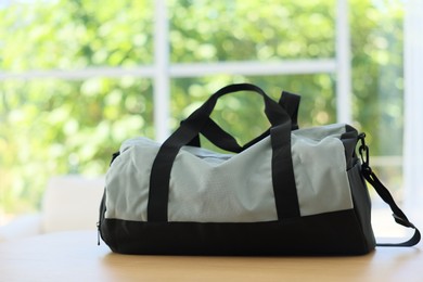 Photo of Stylish sports bag on wooden table indoors