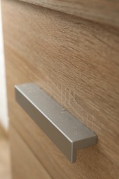 Photo of Handle of dresser covered with dust indoors, closeup