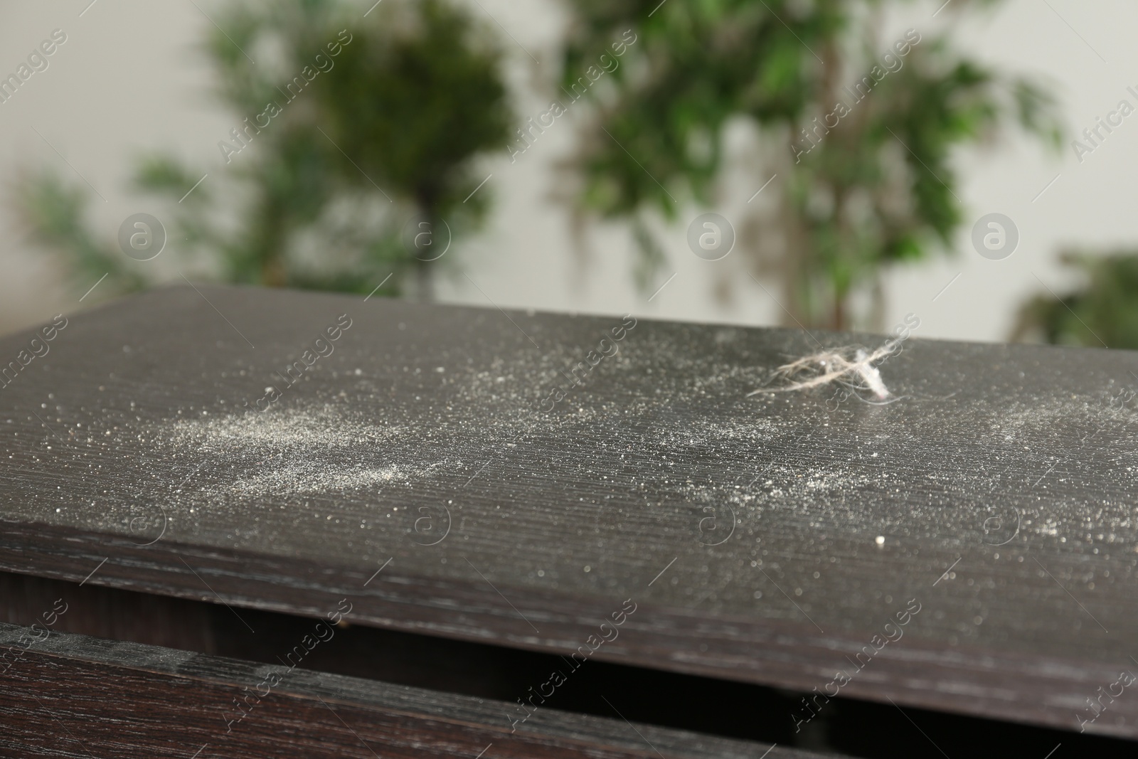 Photo of Black wooden table covered with dust indoors, closeup