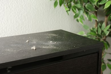 Photo of Black wooden cabinet covered with dust indoors, closeup