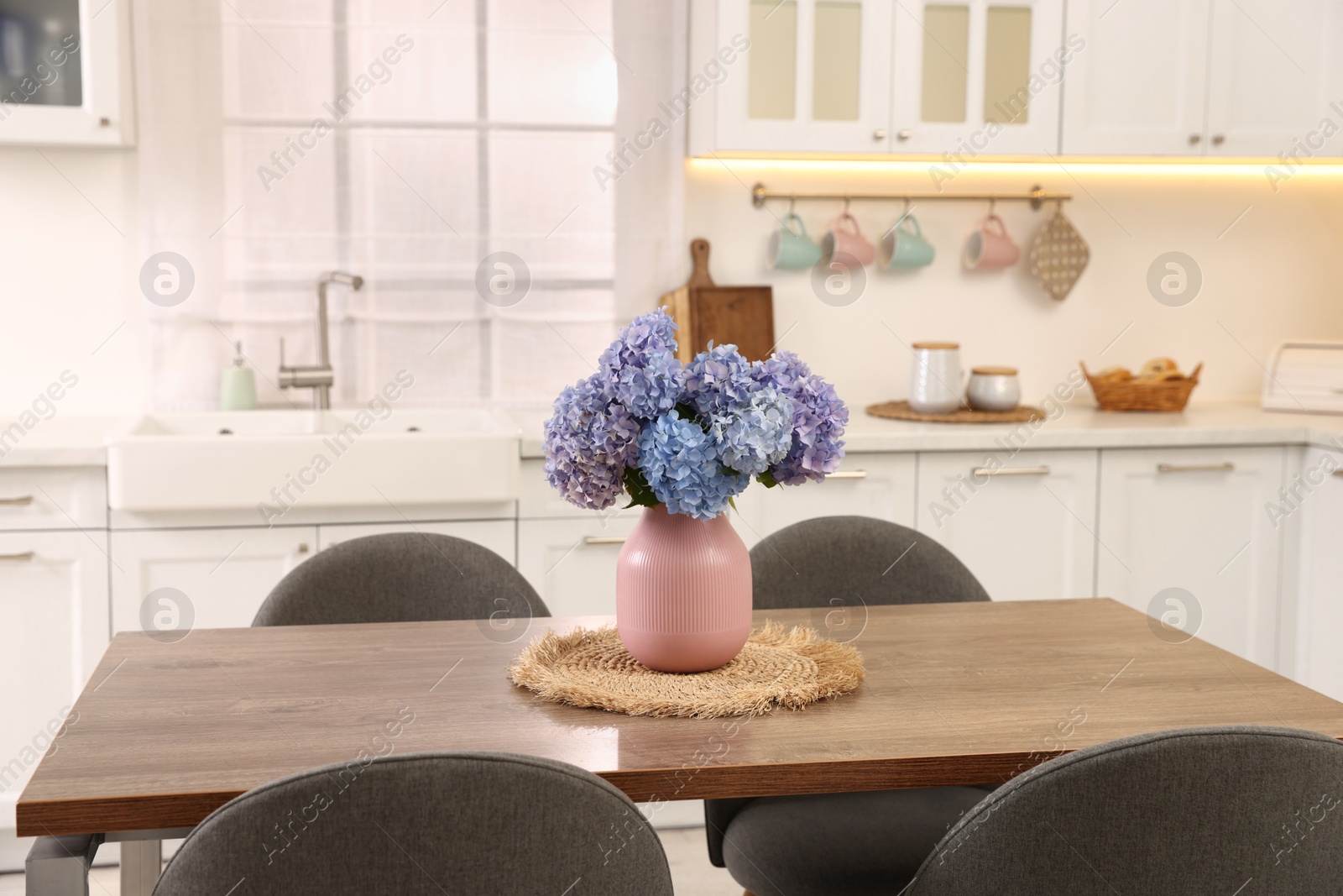 Photo of Dining table, chairs and floral decor in kitchen. Interior design