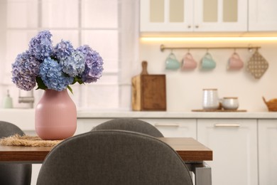Photo of Dining table, chairs and floral decor in kitchen. Interior design